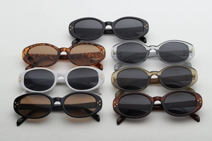 Detail view of oval sunglasses with gold cross star rivets in seven assorted colors