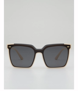 Detail of square oversized sunglasses with two-tone cream and black frame and gold metal trim