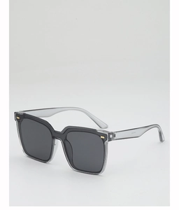 Detail shot of square gray sunglasses featuring gold metal accents on translucent frames