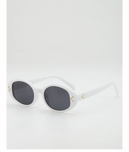 Close-up of golden floral detail on white oval sunglasses frame with dark lenses