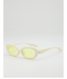 Detail view of oval cream resin frame sunglasses with light yellow tinted lenses