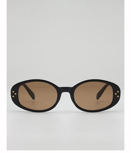 Close-up of black oval sunglasses featuring gold star studs and brown tinted lenses