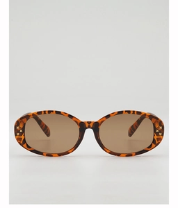 Detail of tortoise shell oval sunglasses frame with gold star studs and brown lenses