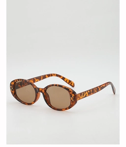 Macro detail of tortoiseshell oval sunglasses with star-shaped gold metal accents