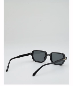 Detail view of square black sunglasses with golden metal hinge accent and dark grey lenses