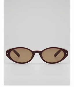 Detail of oval sunglasses with wine red frame and silver star studs on the front