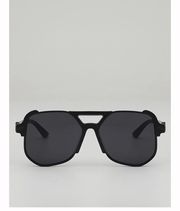 Close-up of oversized black sunglasses with unique top frame bridge and dark grey lenses