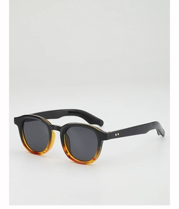 Detailed view of round retro sunglasses with tortoiseshell accents and metal dot hinges