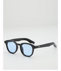 Detailed side view of black thick-frame sunglasses with blue lenses and gold rivets