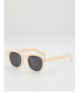 Detail of retro cream round sunglasses with dark grey lenses and metal hinge accents