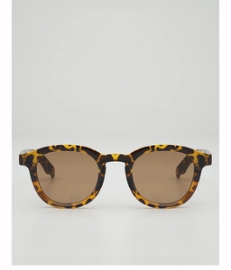 Detailed view of round tortoiseshell sunglasses with classic amber textures and brown lenses