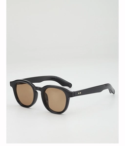 Close-up of retro round black sunglasses with brown lenses and metal dot details