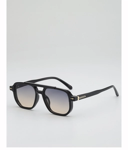 Close-up of luxury aviator sunglasses with gold arrow rivets and gradient lenses