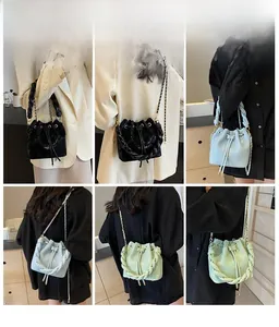 Detail view of drawstring bucket bags with chain straps in black, blue and green colors