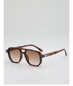 Detail of tortoise shell navigator sunglasses with gradient lenses and gold accents