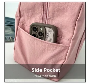 Dettaglio della borsa a tracolla in nylon rosa con tasca laterale funzionale per smartphone