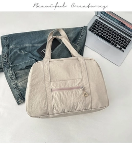 Dettaglio borsa tote in nylon beige con zip metallica e manici ampi per uso quotidiano