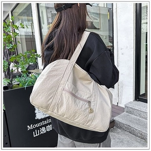 Dettaglio della borsa a tracolla beige in tela capiente con tasca con cerniera