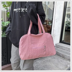Dettaglio della grande borsa tote rosa in tela con tasca frontale a zip e doppi manici lunghi