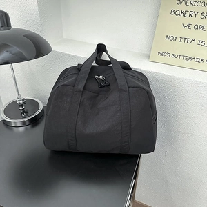 Dettaglio della borsa da viaggio in nylon nero impermeabile con doppi manici e cerniera
