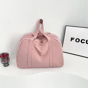 Dettaglio della borsa da viaggio rosa capiente con manici robusti e zip di chiusura