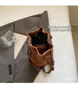 Interior view showing the large capacity of the dark brown suede bucket bag with drawstring