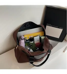 Top view of spacious dark brown canvas shoulder bag interior with daily essentials
