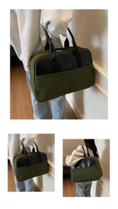 Detail view of a large dark green and black canvas tote bag with a spacious front pocket