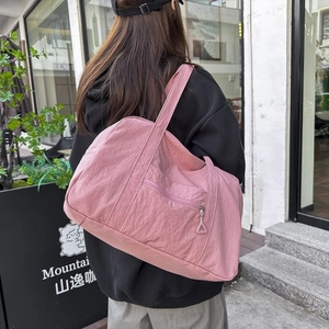 Versatile borsa a tracolla in nylon rosa chiaro da donna in un ambiente casual lifestyle