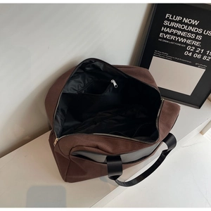 Detail shot of the spacious black interior lining and zippered inner pocket of the brown tote