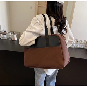 Model view of large canvas tote bag with black leather straps in a cafe setting