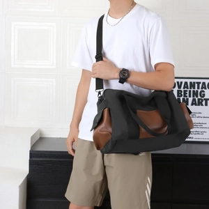 Détail d'un grand sac de voyage en toile avec panneaux en cuir noir et marron et poche latérale