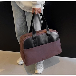 Close-up of canvas tote bag showing black leather trim and sturdy woven handles