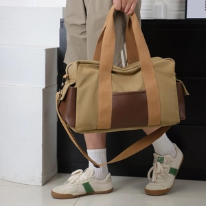 Sac de voyage spacieux en toile kaki avec détails en cuir et bandoulière réglable