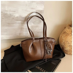Detailed view of brown pleated PU leather tote bag with black cat and chocolate charms