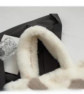 Detail of wide plush shoulder strap on a beige and brown faux fur tote bag