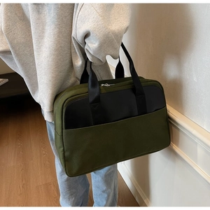 Detail of army green canvas tote bag with black contrast pocket and nylon handle