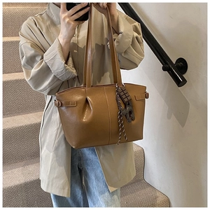 Brown pleated PU leather tote bag detail with chocolate pendant and shoulder strap