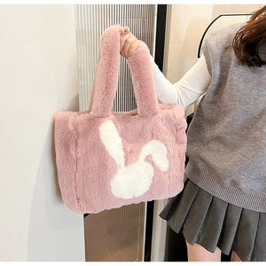 Close-up of pink faux fur tote bag featuring a white rabbit motif and soft texture