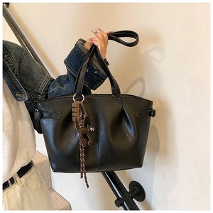 Detail of black pleated PU tote bag featuring a cute cat and chocolate charm pendant