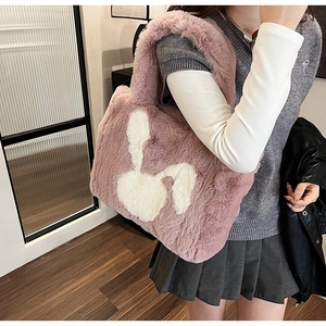 Detail of pink plush tote bag with white rabbit patch showing soft faux fur texture