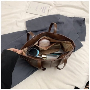 Deep brown tote bag interior with zipper pocket showing daily commute storage space