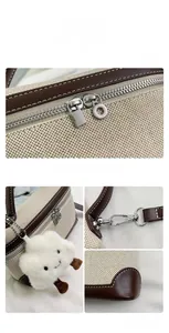 Detail view of canvas leather handbag with silver zippers and plush cloud charm