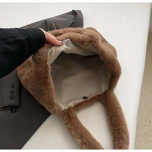 Brown plush tote bag with magnetic closure and spacious interior in top-down view