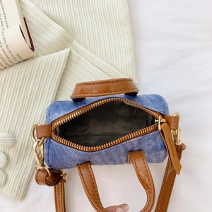 Mini denim cylinder handbag with brown leather straps and gold hardware details