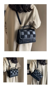 Close-up of black leather and suede patchwork textured flap bag with gold hardware detail