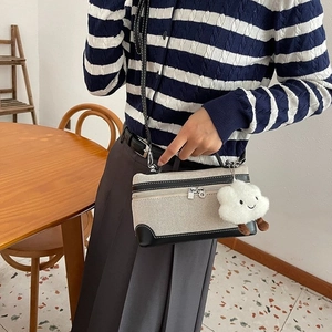 Canvas crossbody bag with black leather trim and white plush cloud charm accessory