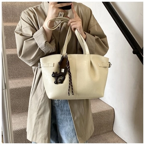 Minimalist beige PU leather tote bag with a cute cat pendant and adjustable side buckles