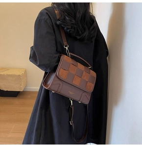 Brown checkerboard patchwork crossbody bag shown on model with gold hardware details