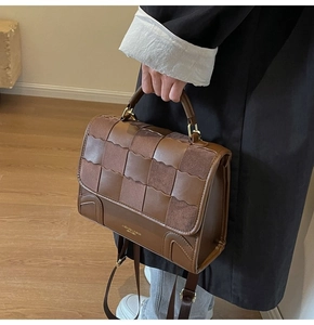 Detail of brown woven leather texture and logo embossed on the handbag bottom